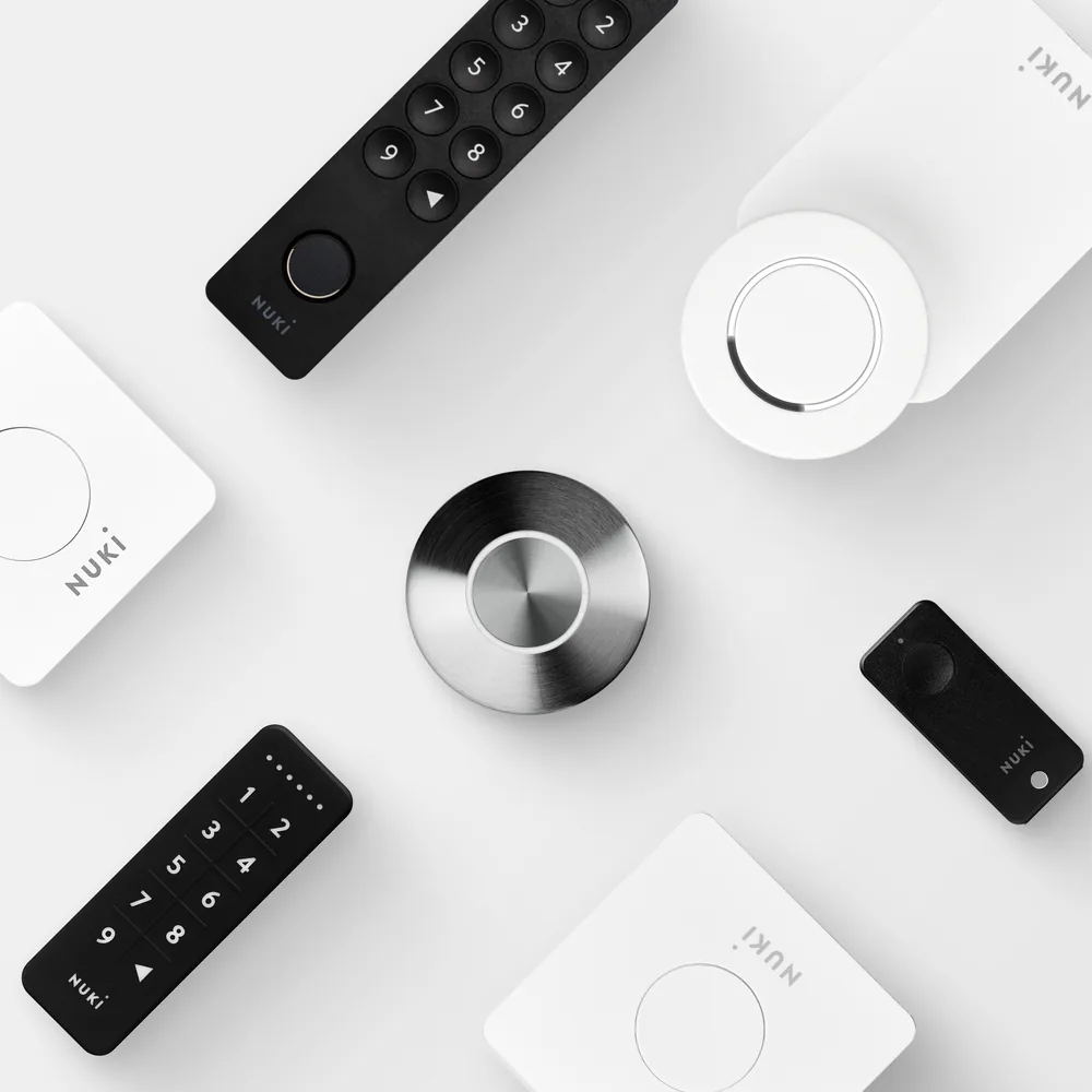 La gamma Nuki dall'alto: Smart Lock Ultra e Go, Keypad 2, Keypad, Fob, Bridge e Opener su fondo bianco