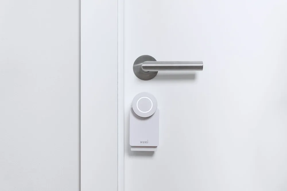 Smart Lock Go montata sotto la maniglia di una porta bianca
