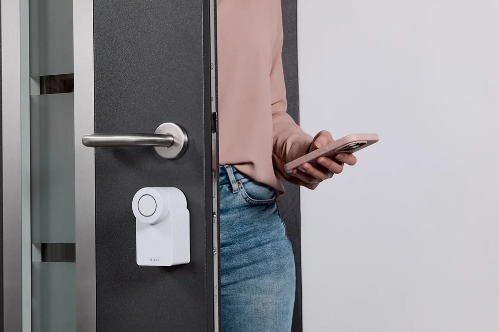 Persona che apre con lo smartphone una porta dotata di Smart Lock Go